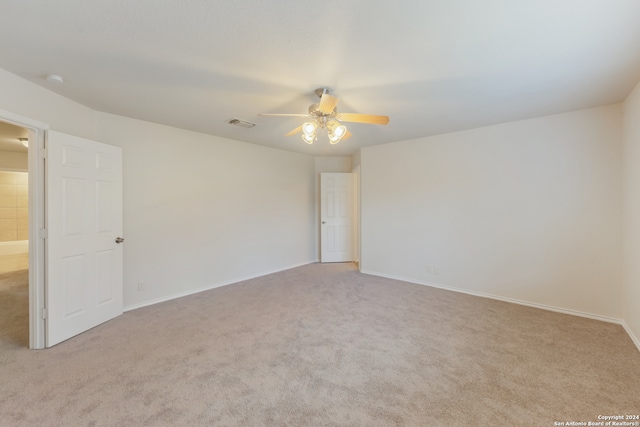 unfurnished room with light colored carpet and ceiling fan