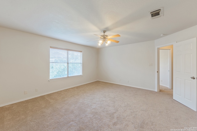 spare room with ceiling fan and light colored carpet