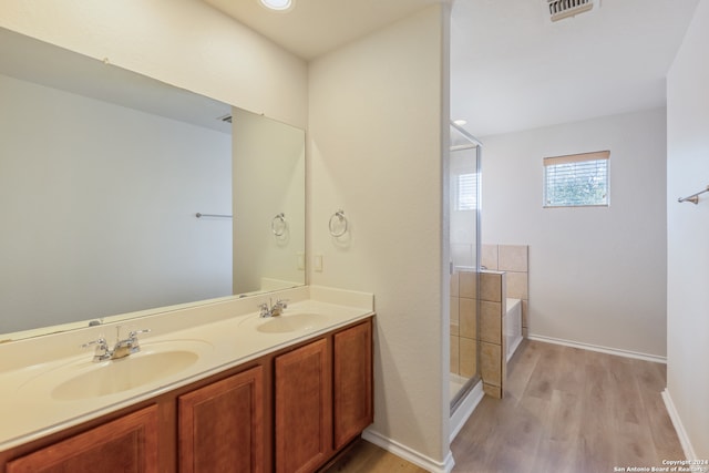 bathroom featuring hardwood / wood-style floors, vanity, and independent shower and bath