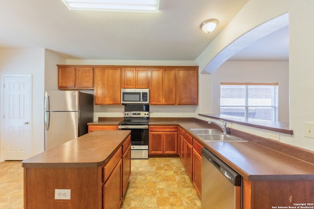 kitchen with stainless steel appliances, sink, and a center island