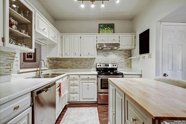 kitchen with appliances with stainless steel finishes, butcher block countertops, sink, and white cabinets