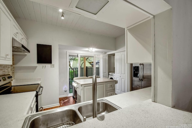 kitchen featuring stainless steel range with electric stovetop, hardwood / wood-style floors, white cabinets, washer / clothes dryer, and kitchen peninsula