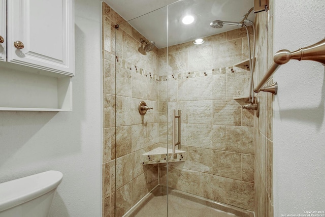 bathroom featuring toilet and tiled shower