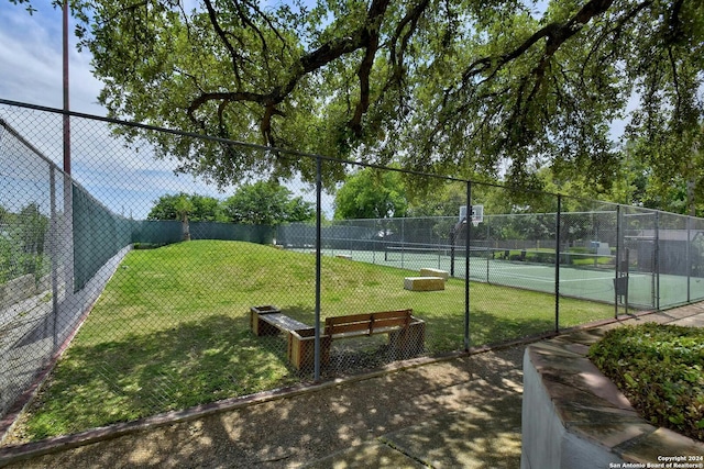 view of home's community featuring a yard and tennis court