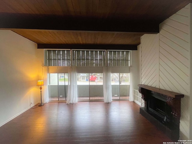 unfurnished living room featuring hardwood / wood-style floors, beam ceiling, and wooden ceiling