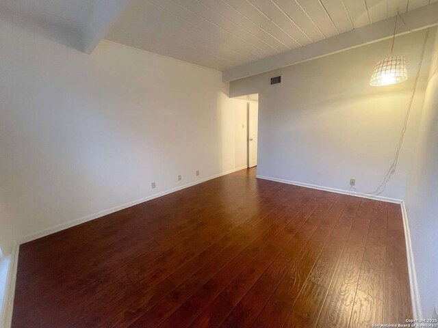 unfurnished room with wood ceiling, beam ceiling, and dark hardwood / wood-style floors