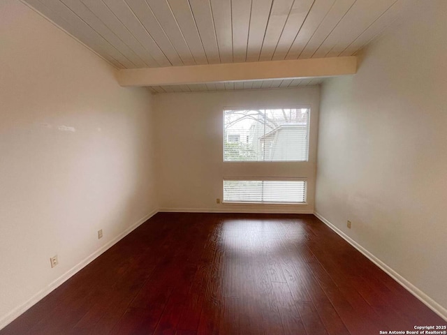 spare room featuring beamed ceiling, hardwood / wood-style floors, and wooden ceiling