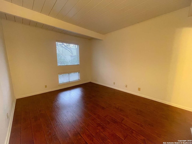 unfurnished room featuring dark wood-type flooring, wooden ceiling, and beamed ceiling