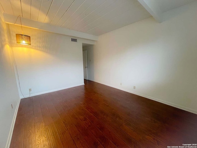 unfurnished room with beamed ceiling, dark hardwood / wood-style floors, and wood ceiling