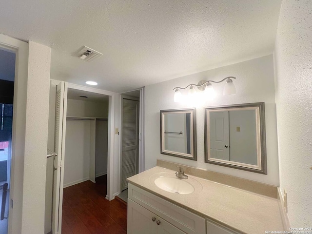 bathroom with vanity, hardwood / wood-style flooring, and a textured ceiling