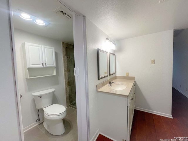 bathroom with hardwood / wood-style flooring, vanity, a shower with shower door, and toilet