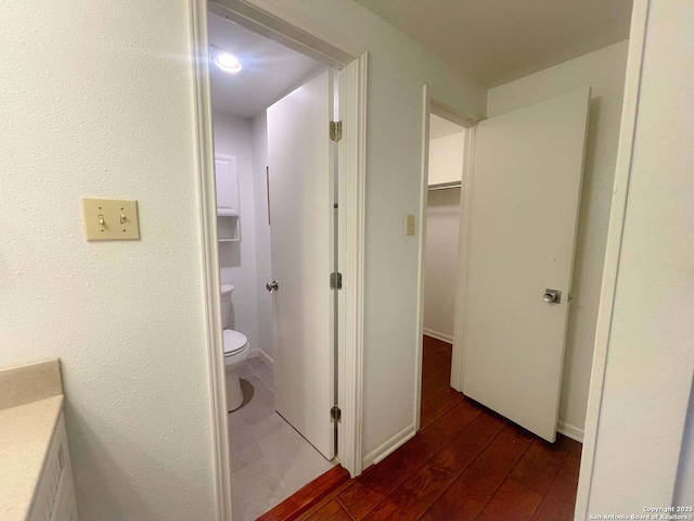 corridor with dark hardwood / wood-style flooring