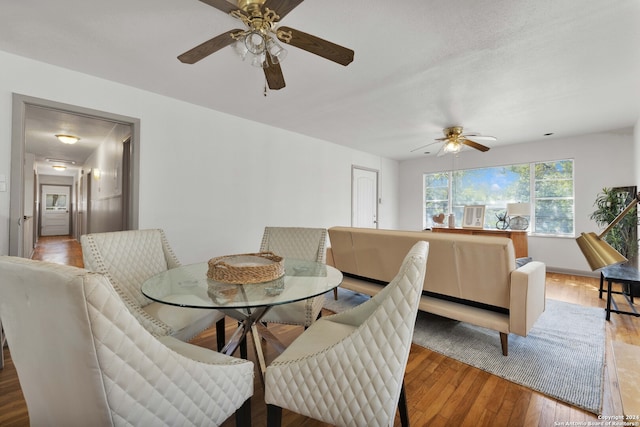 dining space featuring wood-type flooring and ceiling fan