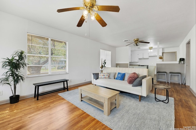 living room with light hardwood / wood-style floors and ceiling fan