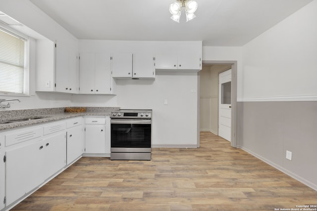 kitchen with light wood-type flooring, sink, white cabinetry, and electric stove