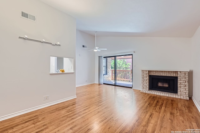 unfurnished living room featuring a brick fireplace, light hardwood / wood-style flooring, high vaulted ceiling, and ceiling fan