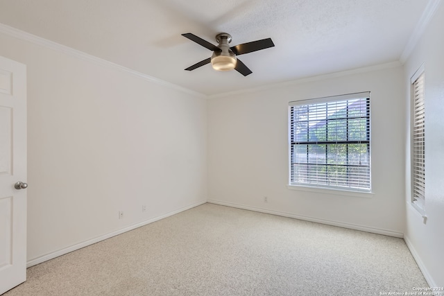 carpeted spare room with crown molding and ceiling fan