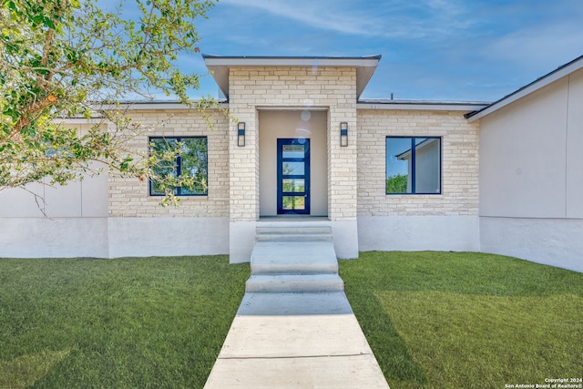 entrance to property featuring a yard