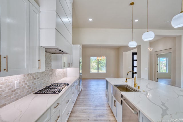 kitchen with light stone countertops, decorative light fixtures, and a healthy amount of sunlight