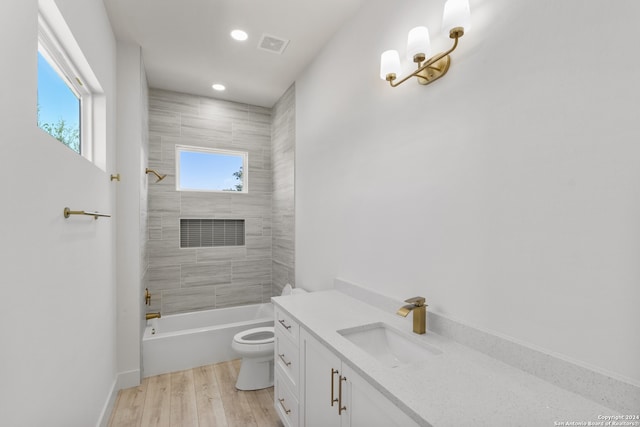 full bathroom with hardwood / wood-style flooring, vanity, a wealth of natural light, and toilet