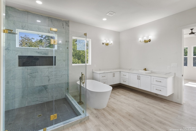 bathroom with hardwood / wood-style floors, a healthy amount of sunlight, vanity, and shower with separate bathtub