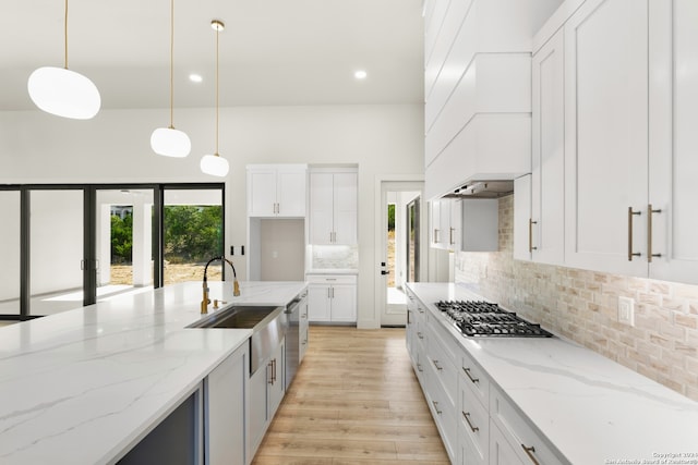 kitchen with white cabinets, decorative light fixtures, and sink