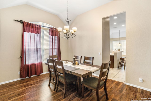 dining room featuring an inviting chandelier, hardwood / wood-style flooring, and lofted ceiling