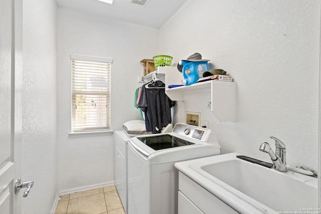 clothes washing area with light tile patterned floors, sink, and independent washer and dryer