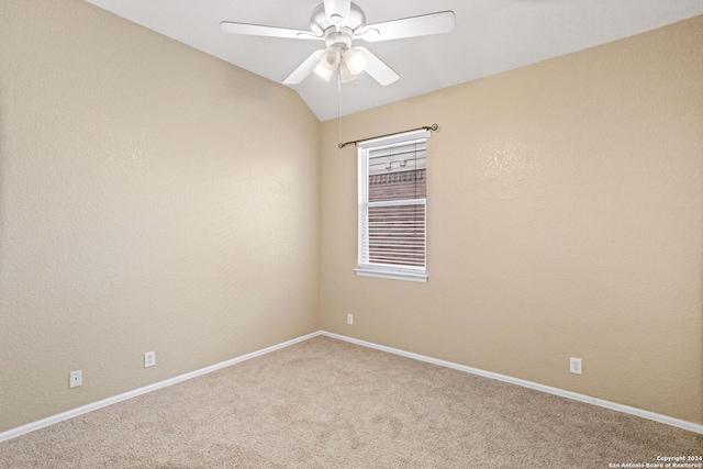 spare room with ceiling fan, vaulted ceiling, and carpet flooring