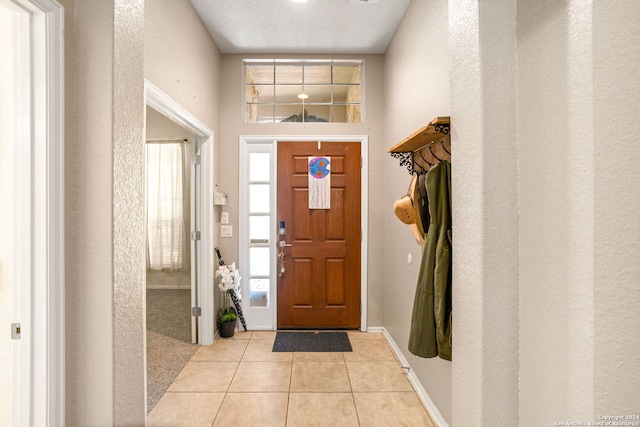 tiled entryway featuring a textured ceiling