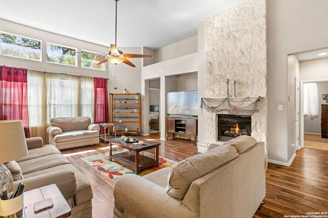 living room featuring ceiling fan, a towering ceiling, and dark hardwood / wood-style flooring