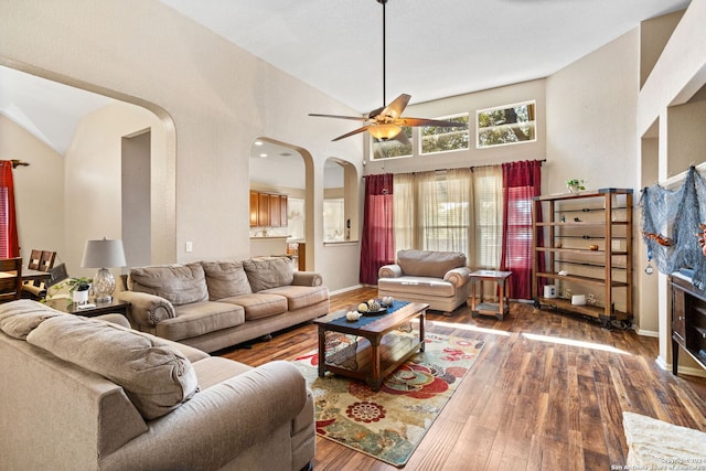 living room with ceiling fan, dark wood-type flooring, and high vaulted ceiling