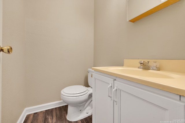 bathroom featuring vanity, toilet, and hardwood / wood-style flooring