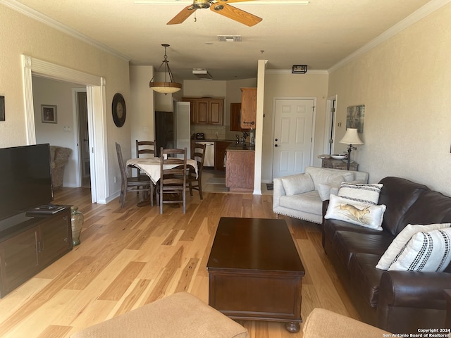 living room featuring crown molding, light hardwood / wood-style flooring, and ceiling fan