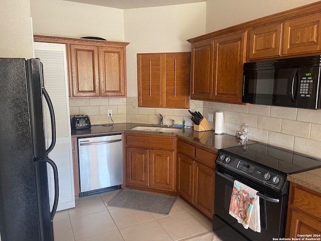 kitchen featuring black appliances, sink, light tile patterned floors, and backsplash