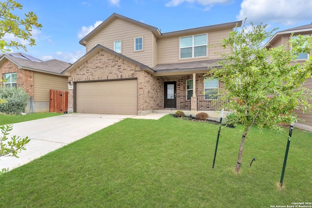 view of front of home with a garage, a front yard, and covered porch