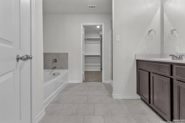 bathroom with vanity, a bath, and tile patterned floors