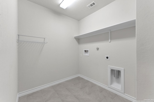 laundry room with hookup for an electric dryer, a textured ceiling, hookup for a washing machine, and gas dryer hookup