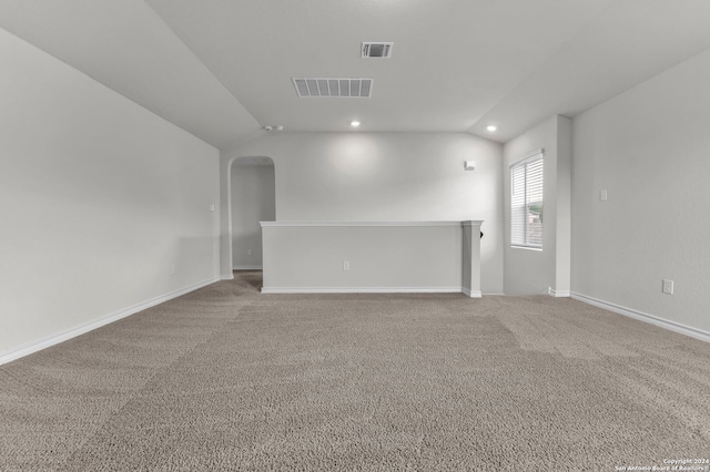 unfurnished living room featuring vaulted ceiling and carpet