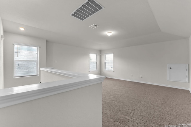 carpeted empty room featuring lofted ceiling and a healthy amount of sunlight