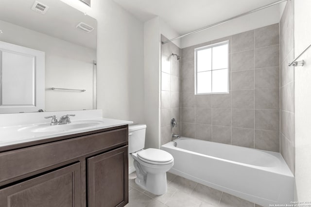 full bathroom with toilet, tiled shower / bath, tile patterned floors, and vanity