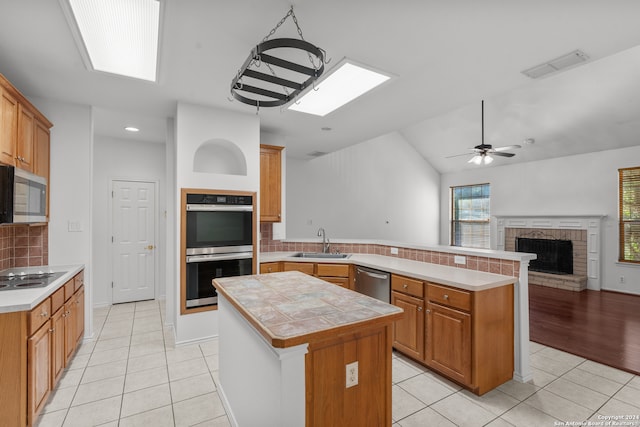 kitchen with stainless steel appliances, kitchen peninsula, decorative backsplash, and a center island