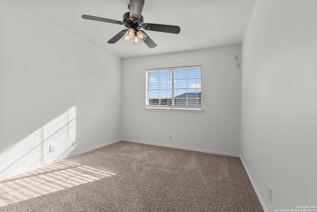 carpeted spare room with baseboards and ceiling fan