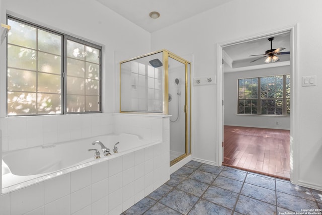 full bath with baseboards, a ceiling fan, a shower stall, and a bath