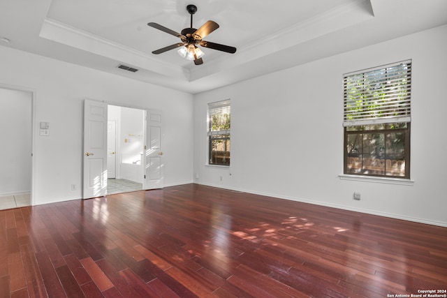 unfurnished room featuring wood-type flooring, a tray ceiling, and plenty of natural light