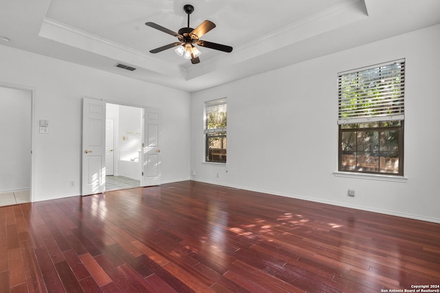 interior space with visible vents, crown molding, a tray ceiling, and hardwood / wood-style floors