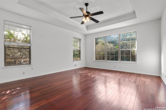 spare room with crown molding, a tray ceiling, hardwood / wood-style flooring, and ceiling fan