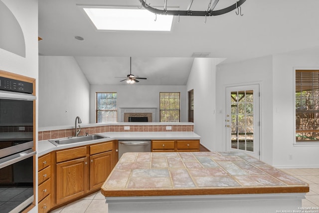 kitchen with light countertops, stainless steel appliances, light tile patterned floors, and a sink