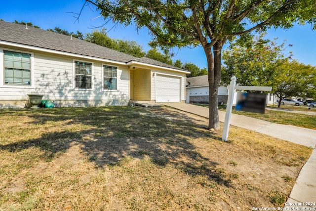 ranch-style house featuring a front lawn and a garage