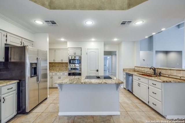 kitchen with a kitchen island, sink, stainless steel appliances, and white cabinets